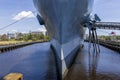 The USS North Carolina surrounded by lush green trees and grass, blue sky and clouds on a summer day at Battleship North Carolina Royalty Free Stock Photo