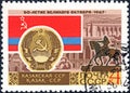 Post stamp printed in the USSR shows Coat of Arms, Flag and monument Kazakh SSR, serie `50 years of the Great October`. Philately