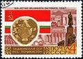 Post stamp printed in the USSR shows Coat of Arms, Flag and monument Tajik SSR, serie `50 years of the Great October`. Philately