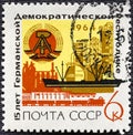 USSR - CIRCA 1964: A stamp printed in USSR shows East German Arms, Industrial Plants, Freighter Havel and Train with