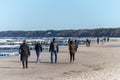 Ustka, Pomorskie / Poland - February, 22, 2019: People walking along the beach on the seashore. A winter walk in sunny weather Royalty Free Stock Photo