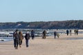 Ustka, Pomorskie / Poland - February, 22, 2019: People walking along the beach on the seashore. A winter walk in sunny weather Royalty Free Stock Photo