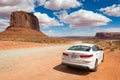 Kia Optima car and famous red rock of Monument Valley. Navajo Tribal Park landscape Royalty Free Stock Photo