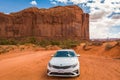 Kia Optima car and famous red rock of Monument Valley. Navajo Tribal Park landscape Royalty Free Stock Photo