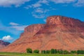 Utah landscape with red Butte and farm