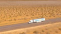 AERIAL: Flying along a Walmart truck hauling a cargo container across the desert