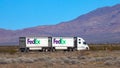 CLOSE UP: Delivery service semi-trailer truck crosses the barren landscape.