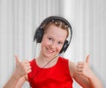 ÃÂ¡ute teen girl listening to music in headphones and showing a thumbs up gesture