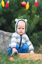 ÃÂ¡ute toddler decorating Christmas tree in backyard. Child in backyard decorates for New Year close-up