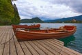 Utiful autumn landscape with three wooden boats moored on Bled Lake Blejsko jezero. Famous touristic place and travel Royalty Free Stock Photo