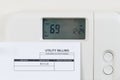 Utility bill with heating thermostat on wall Royalty Free Stock Photo
