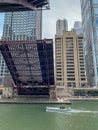 Utility boat travels under a Chicago drawbridge as it opens