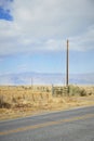 Utility pole in corner of paddock. Cloudy sky Royalty Free Stock Photo