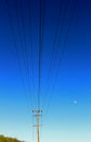 Utility pole and electricity wires and cables, blue sky, moon Royalty Free Stock Photo