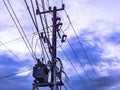 Intricate web of electrical power lines and transformer mounted on a utility pole against dramatic sky Royalty Free Stock Photo
