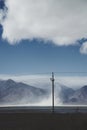 Utility pole and steam rising in front of mountains