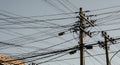 Utility poles overwhelmed by a web of electrical wires Royalty Free Stock Photo