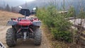 Utility red ATV on a dirt road, close-up, rear view. four-wheeled car. four-wheeled bicycle, all-terrain vehicle. large wheels Royalty Free Stock Photo