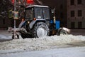 Utility tractor cleans the road from snow