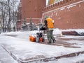 A utility worker cleans snow with a snowplow at the grave of the Unknown Soldier in the Kremlin during a snowfall Royalty Free Stock Photo