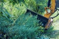 A utility worker using a professional tractor mechanical mower mowing grass mowing tall grass along the side