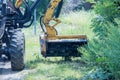 Utility worker using professional tractor mechanical mower to mow grass along side of the road tall grass cutting Royalty Free Stock Photo