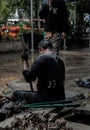 Utility workers using tool to fixing broken water main for commercial building water supplies during a rain