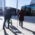 Silhouette of old man behind walker and woman with walking stick Royalty Free Stock Photo