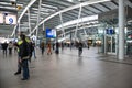 Passengers inside large modern railway terminal concourse