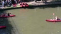 People in canoes paddeling down a canal for fun sporting activity in sunshine