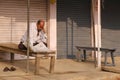 A man reading newspaper at the front of close shops Royalty Free Stock Photo