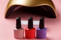 UV lamp lights for nails and set of cosmetic tools for manicure and pedicure on pastel background