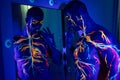 UV patterns body art of the circulatory system on a man`s body. On the chest of a muscular athlete, veins and arteries are drawn