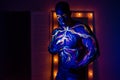 UV patterns body art of the circulatory system on a man`s body. On the torso of a muscular athlete, veins and arteries are drawn