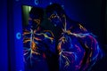 UV patterns body art of the circulatory system on a man`s body. On the chest of a muscular athlete, veins and arteries