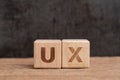 UX User Experience design in product and service concept, cube wooden block building acronym UX on table with blackboard with copy