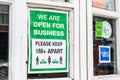 UXBRIDGE, LONDON/ENGLAND- 29 August 2020: WE ARE OPEN FOR BUSINESS social distancing poster in a shop window, amid coronavirus