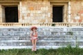 Uxmal, Mexico, 2015-04-20: Old stylish lady sitting at the stairs of ancient pyramid