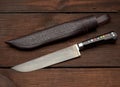 Uyghur Uzbek traditional universal sharp knife with a black handle on a brown wooden background Royalty Free Stock Photo