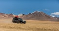 Uyuni, Bolivia, Jeep in the desert with the volcanoes in the background