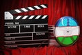 Uzbek cinematography, film industry, cinema in Uzbekistan. Clapperboard with and film reels on the red fabric, 3D rendering