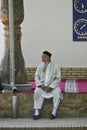 Uzbek man sitting in the courtyard of a mosque in Shahrisabz, Uzbekistan