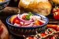 Uzbek national salad achichuk with tomatoes and onion in a bowl with oriental ornament on the wooden table, Oriental, uzbek style