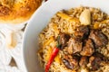 Uzbek Pilaf - Rice with Meat and Vegetables on the table. Pilaf with lamb and garlic zira. close up