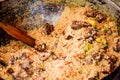 Uzbek plov is cooked in a cauldron on fire in the open air