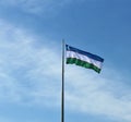 Uzbekistan state flage blue sky and light cloud backgroud, deep blue, white, green, flagpole