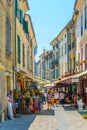 UZES, FRANCE, JUNE 20, 2017: People are strolling through a narrow street in the center of Uzes, FranceUZES, FRANCE, JUNE 20, 2017