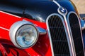 front close-up of a red bmw 321 oldtimer with black hood. sunny outdoor in autumn park