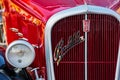 front close-up of a red fiat 508 balilla oldtimer with chrome logo on the grille. sunny outdoor