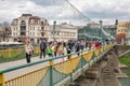 People walk on pedestrian bridge over Uzh river. Uzhhorod, Ukraine